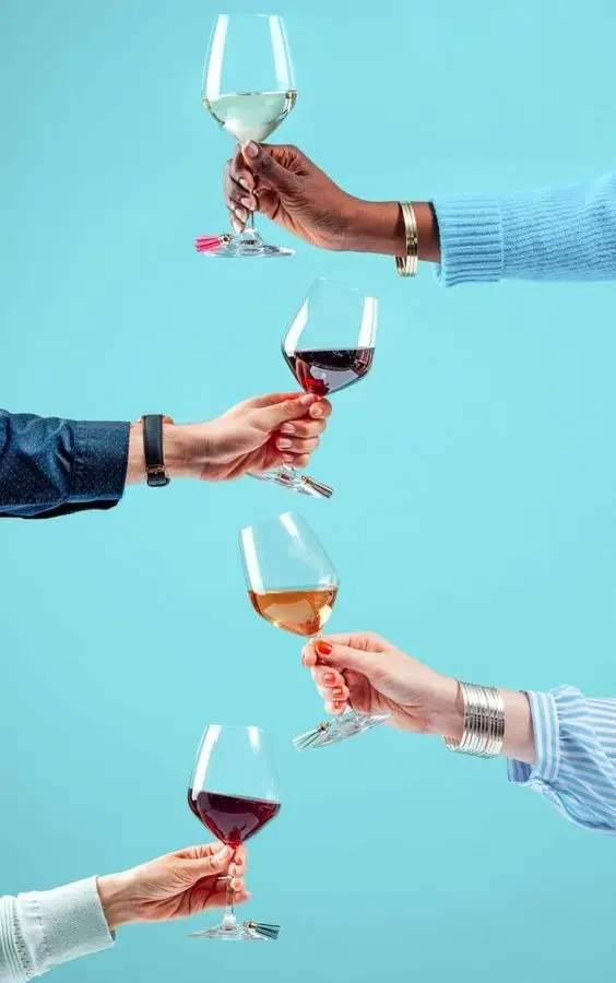 Image de verres de vin tenu par différentes bras de personne